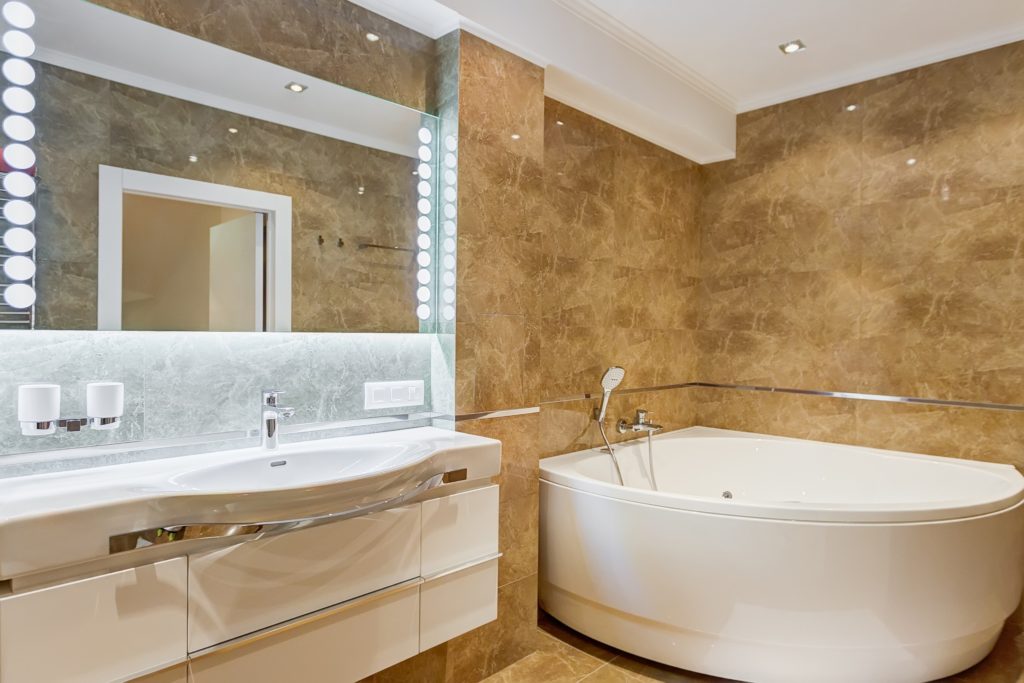 A hotel bathroom with a large white tub.