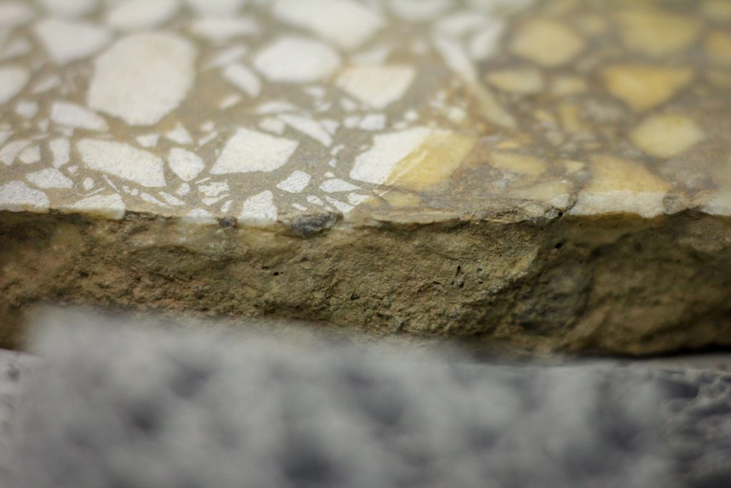 side view of a piece of terrazzo flooring showing different pebbles